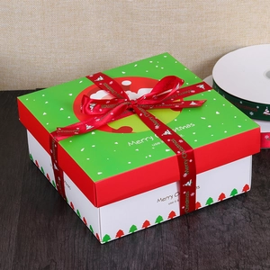 Christmas gift box with red Merry Christmas ribbon on a dark wood background