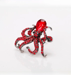Macro shot of octopus brooch with red rhinestones and teardrop gemstone on silver base