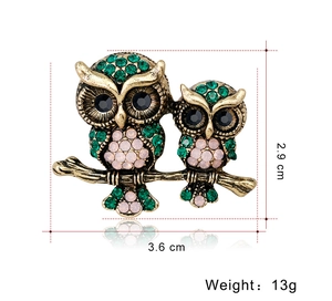 Detailed size view of retro owl brooch in antique gold with green and pink crystals