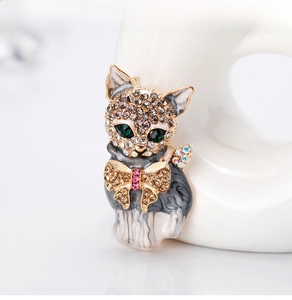 Detail of a cat brooch with green crystal eyes and sparkling rhinestone head inlay