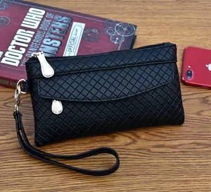 Detail view of black embossed lattice clutch bag with metal zipper and wrist strap