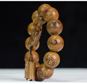 Détail macro de perles de prière en bois de Wengé montrant le grain circulaire naturel