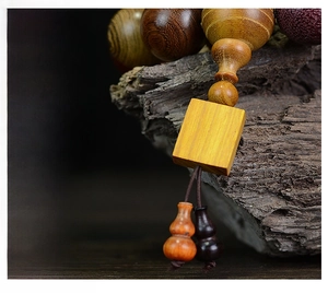 Macro shot of assorted multi-wood prayer beads with a wooden gourd pendant and natural texture