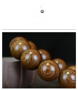Close-up of premium sandalwood prayer beads showing rich oil and natural wood grain