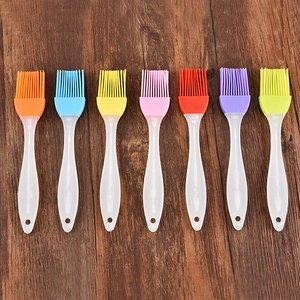 Set of seven colorful silicone pastry brushes with clear handles on wooden surface