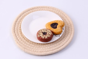 Close-up of cookies on a ceramic plate with a hand-woven beige cotton insulation mat