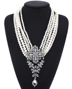 Macro shot of multi-layer faux pearl necklace with ornate crystal drop pendant on mannequin