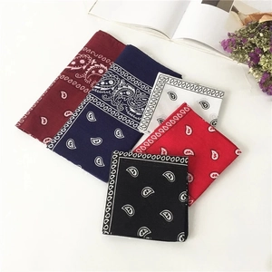 Five paisley bandanas in burgundy, navy, white, red, and black on a white table
