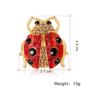 Fashionable ladybug brooch pin with red rhinestones and gold alloy base on white background