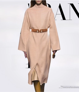 Detail of a brown leather double-buckle belt on an apricot turtleneck maxi dress