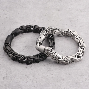 Byzantine chain bracelets for men in silver and black finish on marble surface