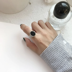 Macro shot of S925 silver ring featuring black onyx with vintage carved wave patterns