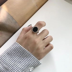 Detail of vintage S925 silver ring with oval black onyx gemstone worn on hand