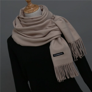 Close-up of solid color cashmere scarf texture with fine tassels on a neck mannequin
