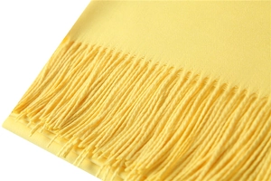 Detailed view of bright yellow cashmere-like scarf texture and long tassels fringe