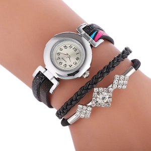 Gros plan d'une montre bracelet avec lanières noires et détails sertis de diamants