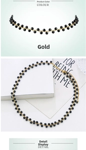 Close-up of golden necklace with faceted black beads and delicate metal chain details
