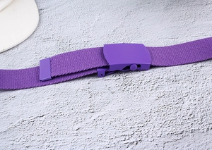 Close-up of purple canvas woven belt featuring a matte smooth buckle and dense texture