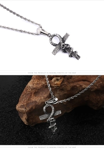 Detail showing an Ankh cross pendant wrapped by a realistic snake on a rugged rock