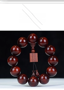 Macro shot of polished red sandalwood beads with natural wood grain and silk tassel