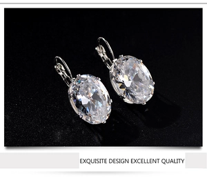 Macro detail of silver earrings with oval-cut cubic zirconia in a lever-back setting