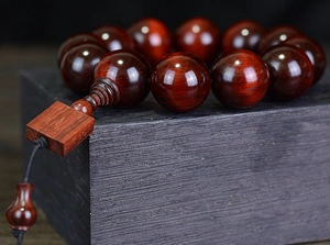 Macro shot of 20mm dark red sandalwood beads showing polished texture and craftsmanship