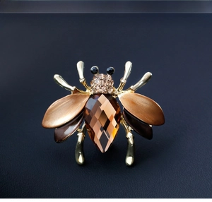 Macro detail of bee brooch featuring large brown crystal and sparkling champagne rhinestones