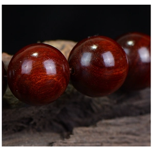 Macro shot of polished red sandalwood beads showing natural wood grain and fine texture