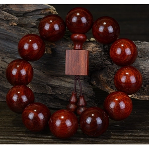 Macro shot of 20mm dark sandalwood beads featuring natural textures and gourd charm