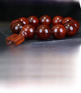 Macro shot of polished Zambian rosewood beads showing clear wood grain and texture