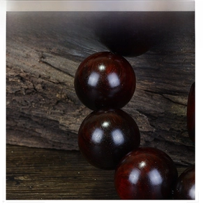 Macro detail of polished Red Sandalwood beads showing fine grain and glossy texture