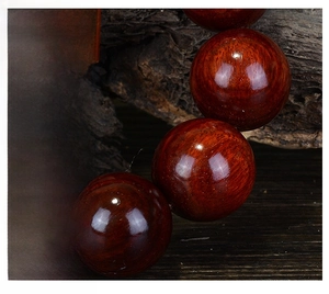 Macro close-up of polished red sandalwood beads with dense wood grain texture