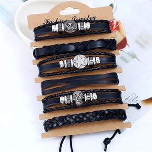 Vintage black braided leather bracelet set with skull and star metal charms on card