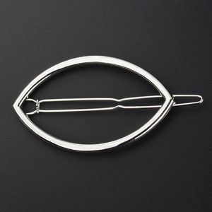 Barrette à cheveux ovale minimaliste en métal argenté avec design ajouré sur fond noir