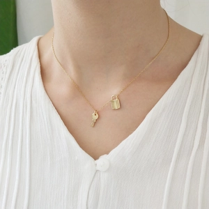 Elegant 925 sterling silver gold necklace featuring a dainty lock and key pendant set