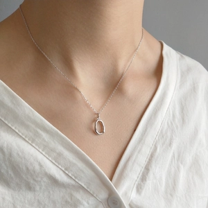 Minimalist 925 sterling silver irregular oval pendant necklace on a female model