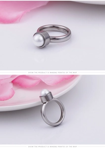 Détail macro d'une bague en acier inoxydable argenté avec une perle blanche pure