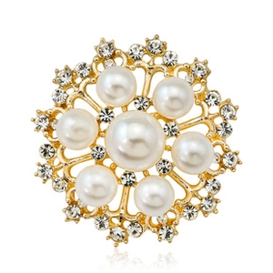 Detail of golden floral brooch with large central pearl and sparkling crystal rhinestones