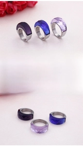 Detailed close-up of three thick stainless steel rings with faceted purple and blue stones