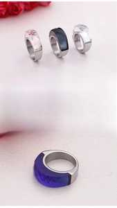 Close-up of faceted crystal inlays on wide stainless steel bands in multiple colors