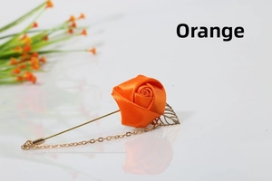 Detailed close-up of handmade orange satin rose brooch with gold leaf and chain accent