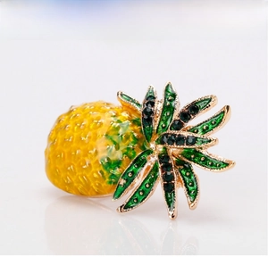 Macro view of pineapple brooch with yellow enamel and inlaid green rhinestones