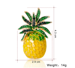 Detailed view of pineapple brooch with green rhinestones and yellow enamel petals