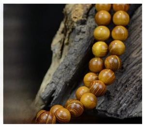 Vue macro de 108 perles en bois de santal montrant le grain naturel et la texture