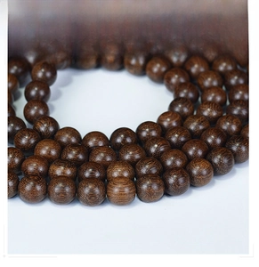 Detailed macro view of natural wood grain on 108 sandalwood prayer beads bracelet
