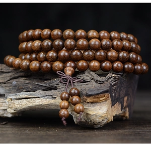 Macro view of 108 sandalwood prayer beads with natural wood grain and brown tassel