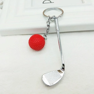 Detailed macro view of the realistic red golf ball and silver club charm on the keychain