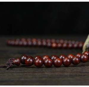 Macro detail of high-density sandalwood prayer beads with natural wood grain texture