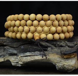 Macro shot of 108 wooden beads on a weathered wood stand with natural textures