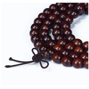 Macro shot of 108 red sandalwood beads with refined wood grain and Chinese knot detail